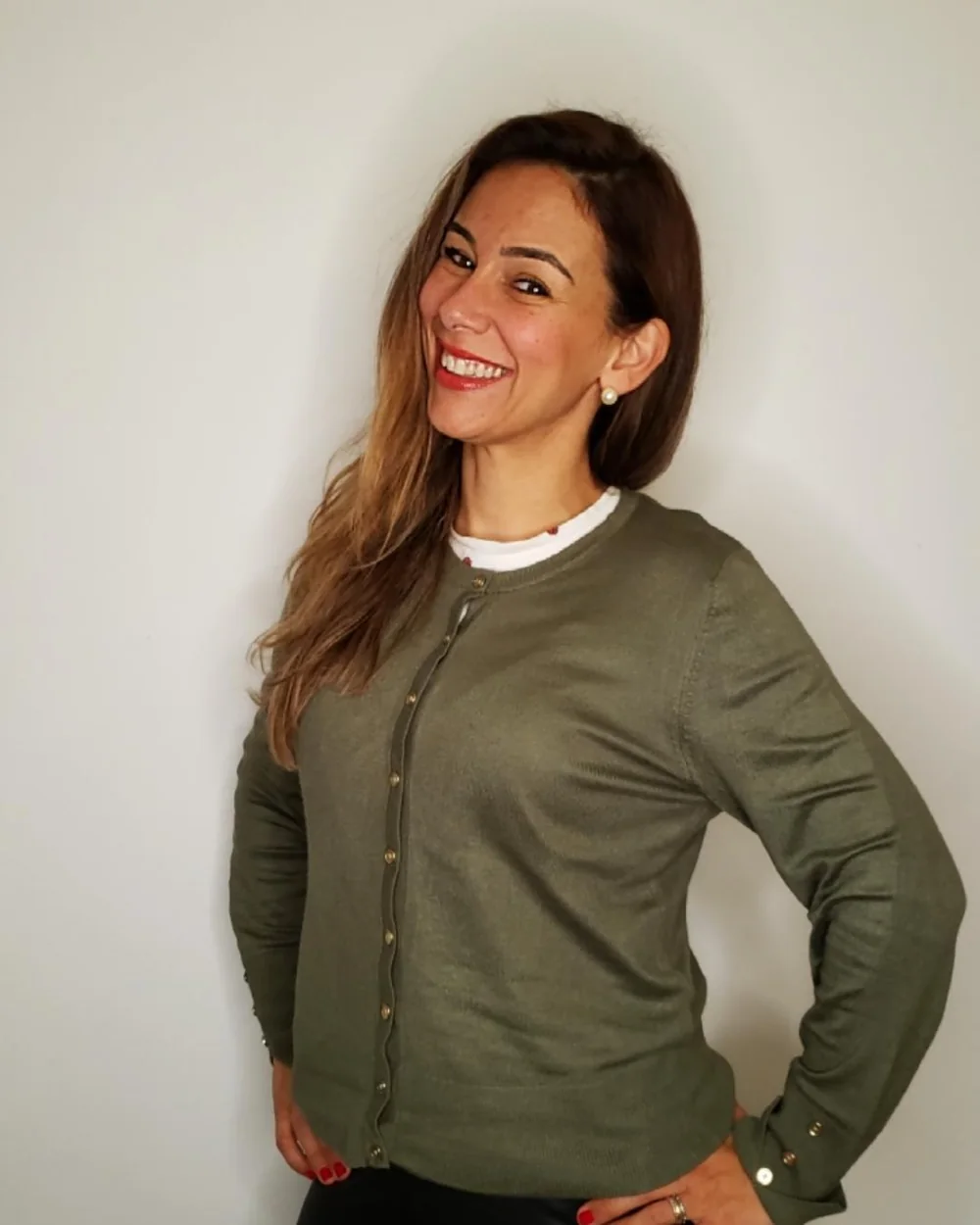 Michele Furiski sorrindo, de casaco verde-oliva